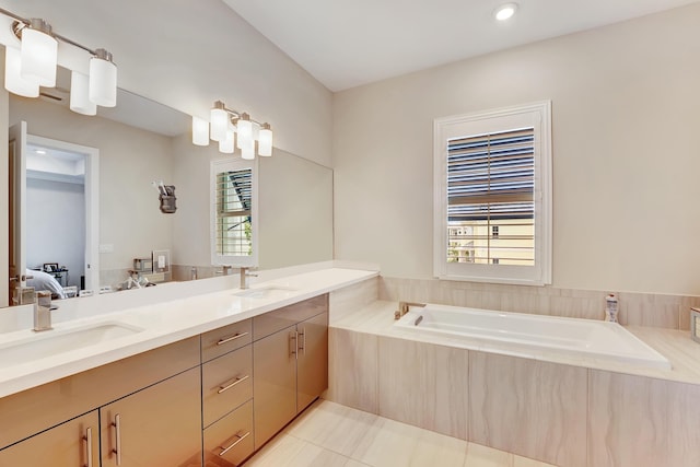 bathroom with vanity, a relaxing tiled tub, tile patterned floors, and a healthy amount of sunlight