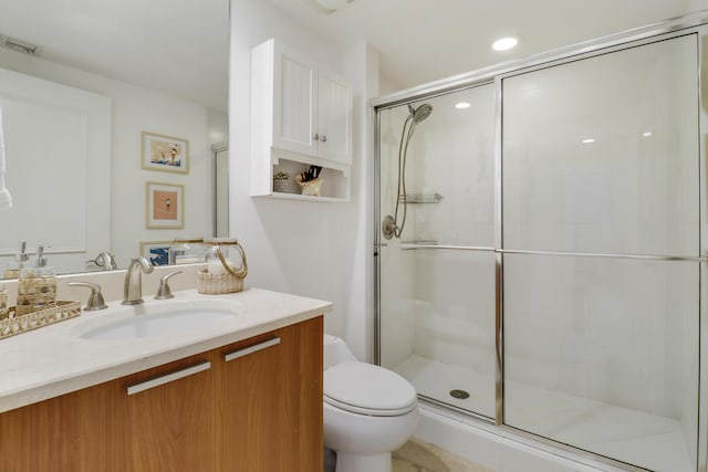 bathroom featuring vanity, toilet, and a shower with door