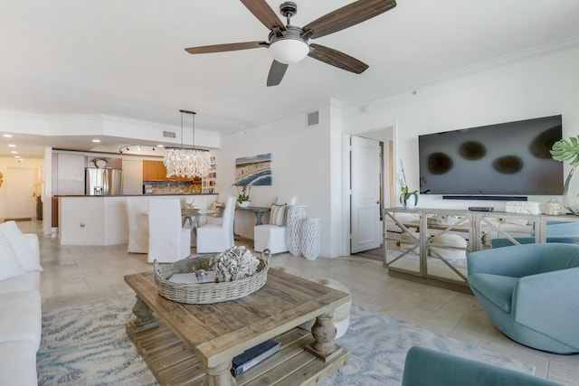 living room with ceiling fan with notable chandelier and crown molding