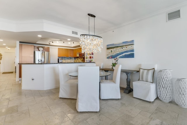 dining space with ornamental molding and a notable chandelier