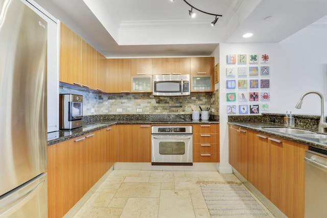 kitchen featuring sink, stainless steel appliances, dark stone countertops, decorative backsplash, and ornamental molding