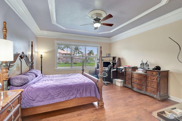 bedroom featuring ceiling fan, crown molding, and a tray ceiling