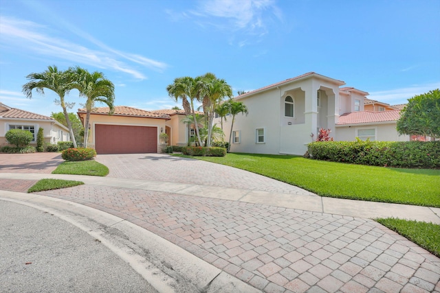 mediterranean / spanish home with a garage and a front lawn