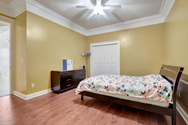 bedroom featuring wood-type flooring, a closet, ceiling fan, and crown molding