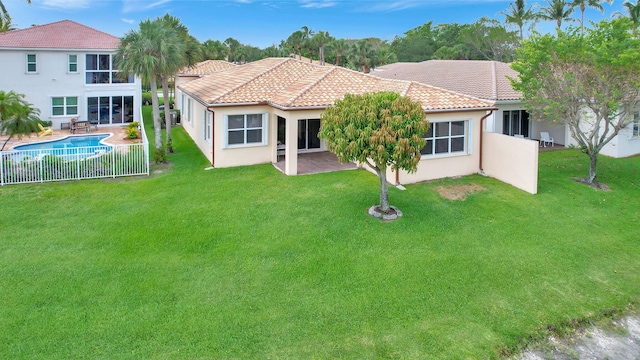 back of house with a lawn and a patio