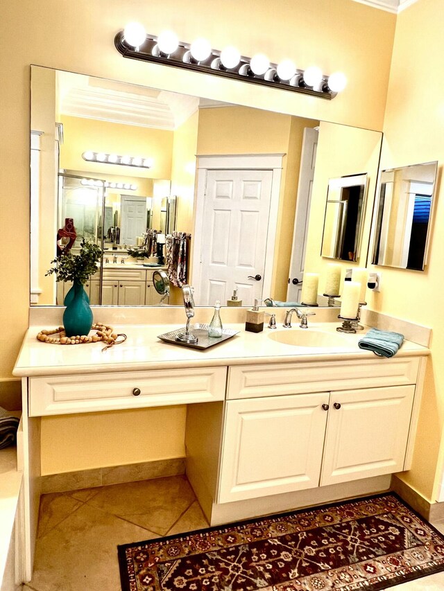 bathroom with vanity, ornamental molding, baseboards, and tile patterned floors