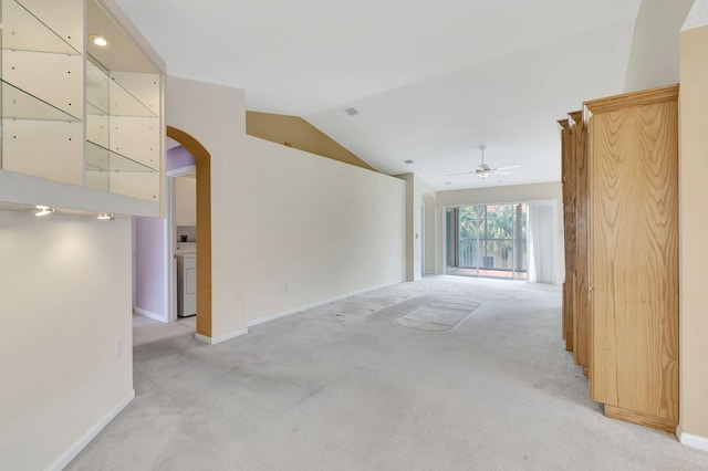 carpeted empty room featuring ceiling fan and vaulted ceiling