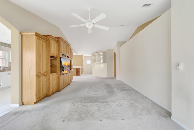 unfurnished living room featuring light tile floors, ceiling fan, and vaulted ceiling