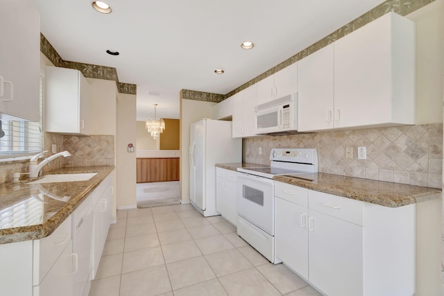 kitchen featuring hanging light fixtures, white appliances, white cabinets, sink, and tasteful backsplash