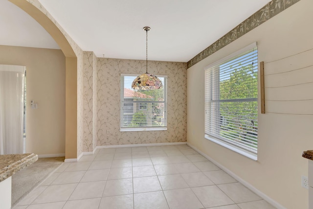 unfurnished dining area with a wealth of natural light and light tile flooring