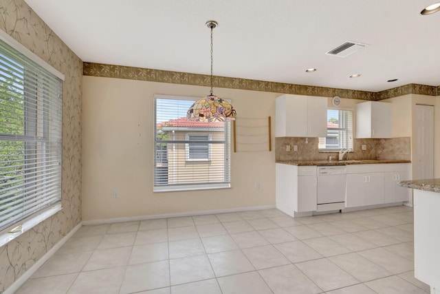 kitchen with white cabinets, decorative light fixtures, tasteful backsplash, dishwasher, and light tile floors