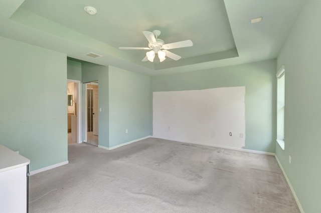 unfurnished room with ceiling fan, carpet, and a tray ceiling