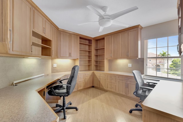 home office featuring ceiling fan, light hardwood / wood-style floors, and built in desk