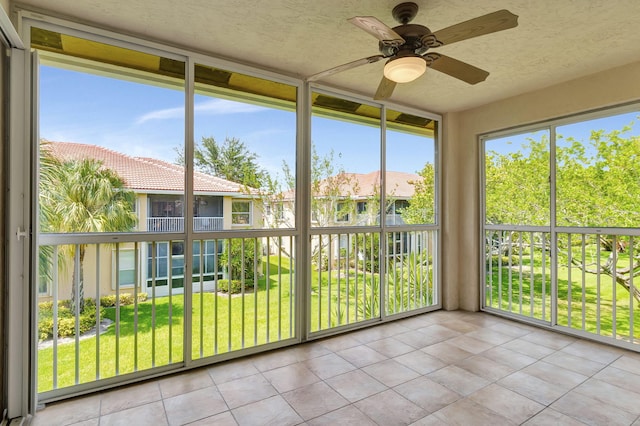 unfurnished sunroom featuring ceiling fan