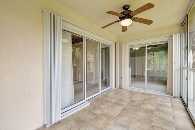 unfurnished sunroom with ceiling fan