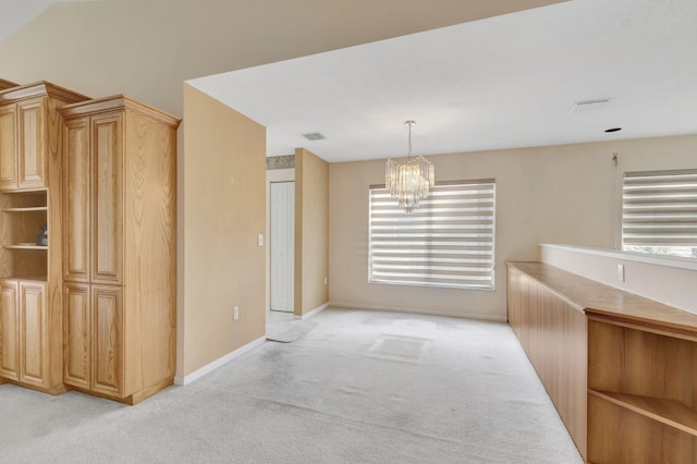 unfurnished dining area with a chandelier and light colored carpet