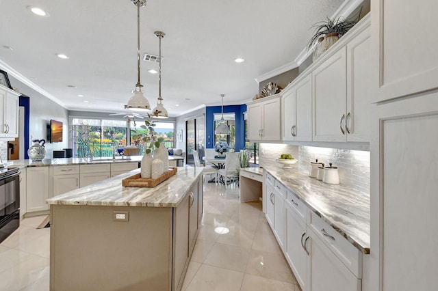 kitchen with kitchen peninsula, ornamental molding, a kitchen island, light stone countertops, and pendant lighting