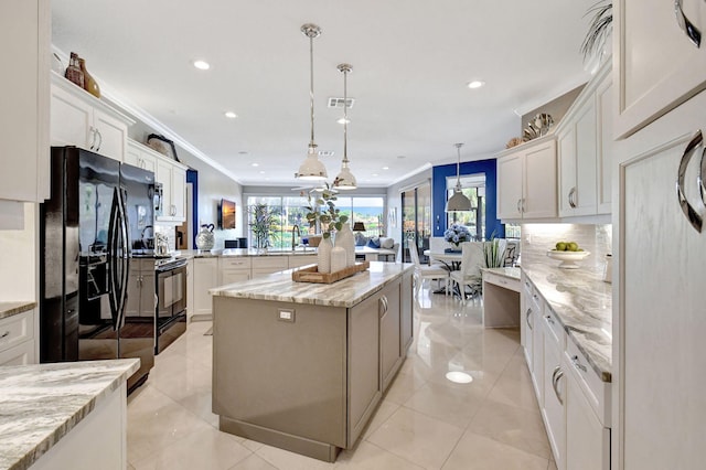 kitchen with white cabinets, black appliances, a kitchen island, crown molding, and decorative light fixtures