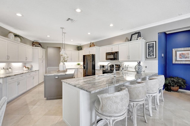 kitchen with black appliances, tasteful backsplash, white cabinetry, pendant lighting, and kitchen peninsula