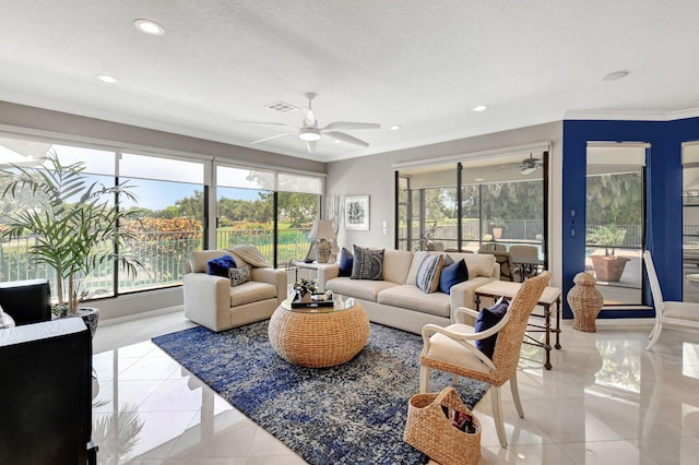 tiled living room with a textured ceiling, a healthy amount of sunlight, and crown molding