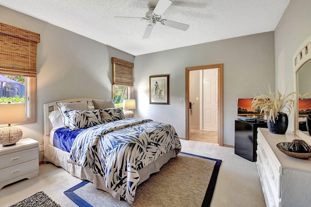 bedroom featuring a textured ceiling, multiple windows, light carpet, and ceiling fan