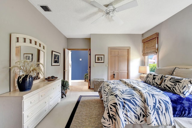 bedroom featuring a textured ceiling, light carpet, ceiling fan, and a closet