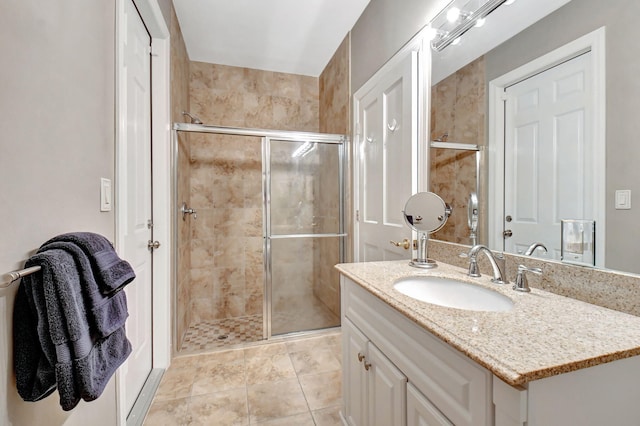 bathroom with an enclosed shower, vanity, and tile patterned floors