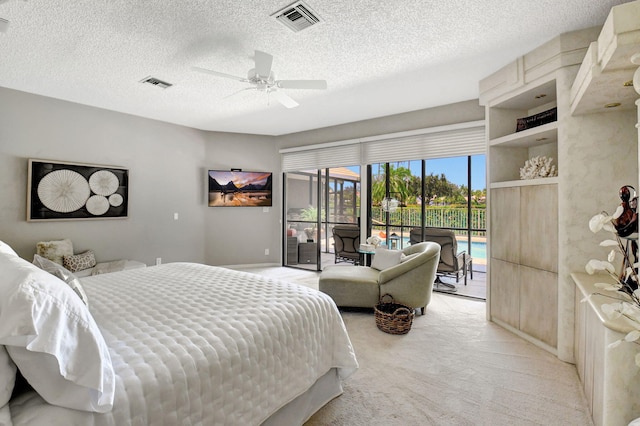 carpeted bedroom with access to exterior, a textured ceiling, and ceiling fan