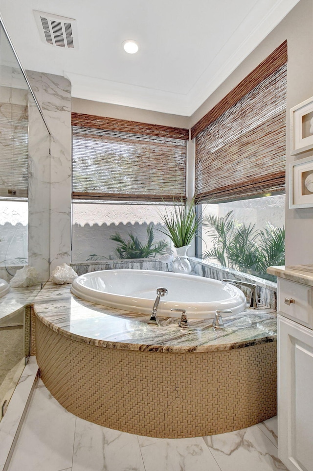 bathroom with ornamental molding, a healthy amount of sunlight, and tiled bath