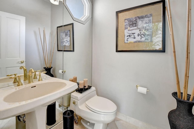 bathroom featuring tile patterned flooring, toilet, and sink