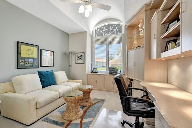 carpeted office featuring lofted ceiling, a textured ceiling, and ceiling fan