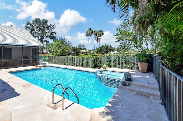 view of pool featuring an in ground hot tub, a patio, and a sunroom