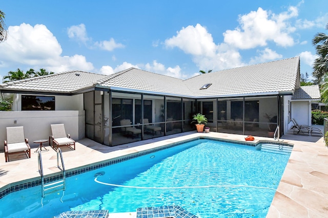 view of swimming pool featuring a patio and a sunroom