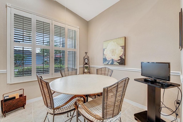 dining area featuring lofted ceiling and light tile patterned floors