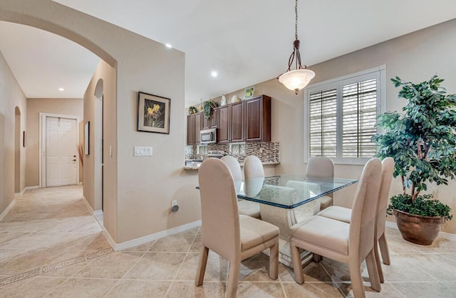 dining room with light tile patterned floors and vaulted ceiling