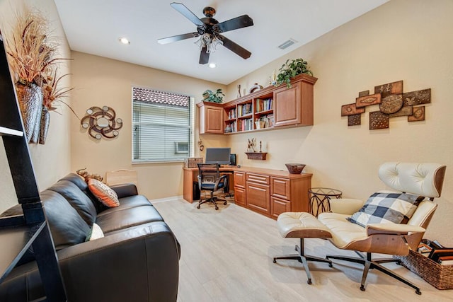 office featuring ceiling fan, built in desk, and light hardwood / wood-style flooring