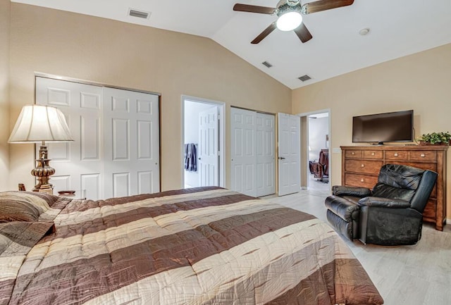 bedroom with vaulted ceiling, ceiling fan, and multiple closets