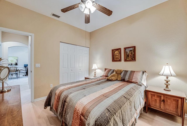 bedroom featuring ceiling fan, light hardwood / wood-style floors, and a closet