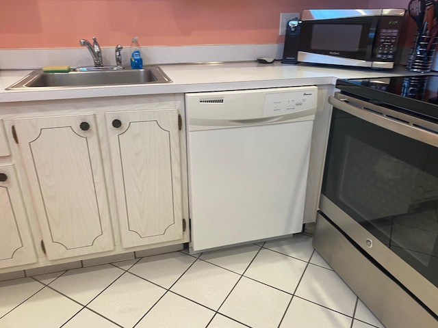 kitchen with sink, light tile patterned floors, and appliances with stainless steel finishes