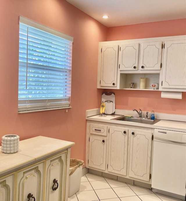 kitchen featuring white dishwasher, sink, and light tile patterned floors