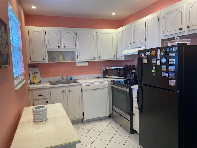 kitchen with stainless steel appliances, sink, white cabinetry, and light tile floors