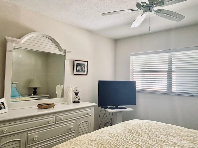 bedroom featuring ceiling fan and a textured ceiling