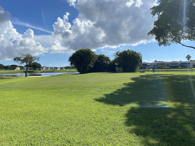 view of property's community with a lawn and a water view