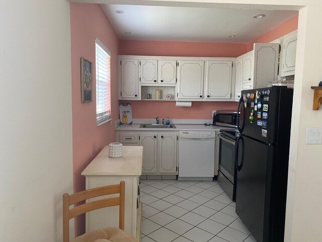 kitchen with black refrigerator, sink, white cabinets, and white dishwasher