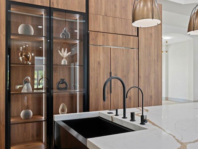 interior details featuring light stone countertops and sink