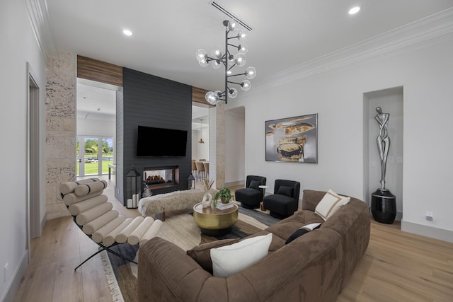 living room with a multi sided fireplace, light hardwood / wood-style flooring, ornamental molding, and a notable chandelier