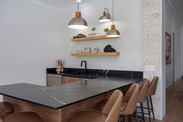 bar featuring dishwasher, sink, crown molding, hardwood / wood-style floors, and decorative light fixtures