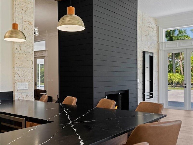 interior space featuring hardwood / wood-style floors, a healthy amount of sunlight, ornamental molding, and a fireplace