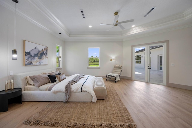 bedroom featuring access to outside, ceiling fan, a tray ceiling, and light wood-type flooring