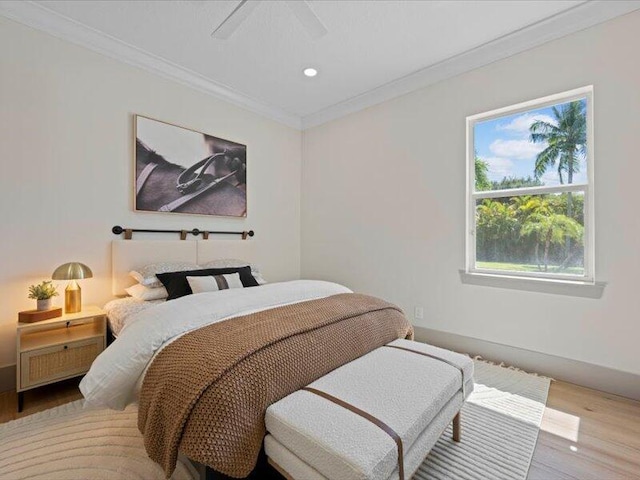 bedroom with hardwood / wood-style flooring, ceiling fan, and crown molding